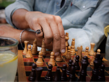 man playing chess with engraved gold signet ring