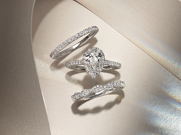 Pear-shaped engagement ring paired with two stackable wedding bands.